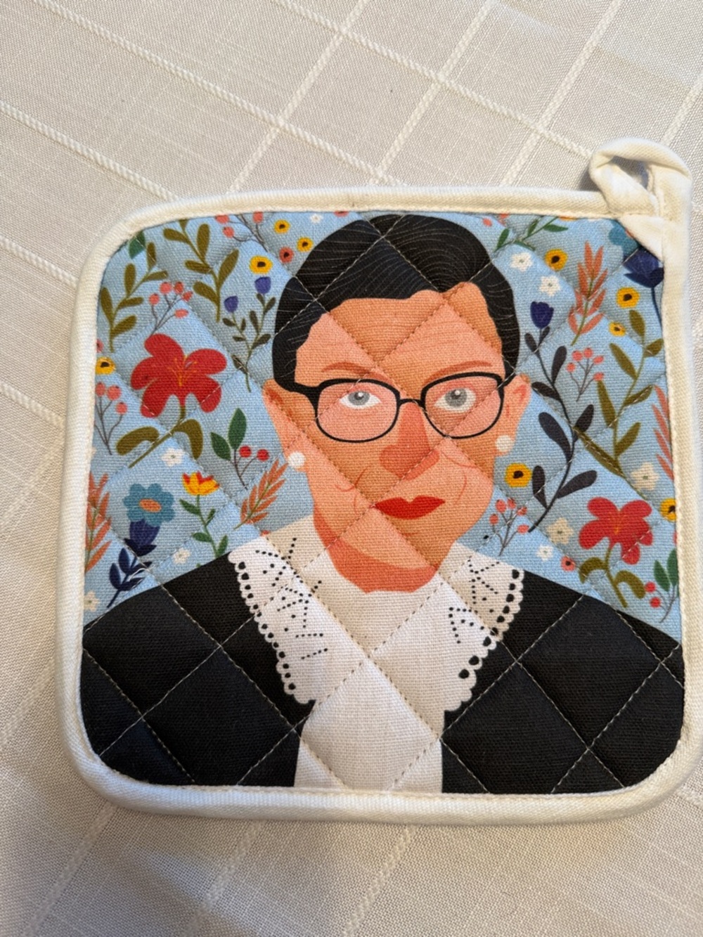 RBG Portrait Potholder - Blue, White, Black & Red with blue background.